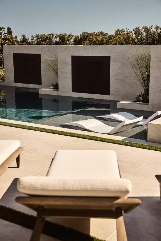 Stylish small backyard pool design featuring modern lounge chairs, sleek water features, and minimalist landscaping, showcasing Urban Landscape's expertise in outdoor transformations.